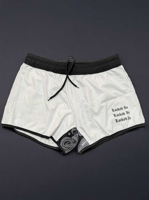 White shorts with black trim and text on a dark background